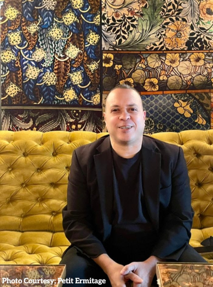 Troy Berry sitting on a couch at The Petit Ermitage Hotel